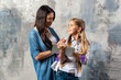 © speed300 - Happy mother  hugs her daughter  who holding ipad.  - Image