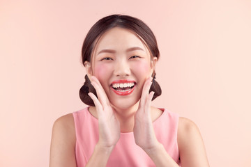 Beautiful asian girl with professional makeup and stylish hairstyle  isolated on pink. Cosmetics and make-up