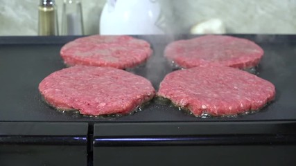 Wall Mural - Hamburger patties sizzling on a grill