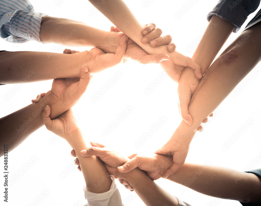 Close up of teamwork holding hands and supporting each other - obrazy, fototapety, plakaty 