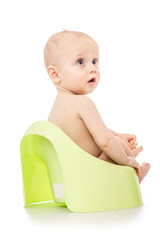 Infant child baby boy toddler sitting on potty toilet isolated on a white background. spoiled kid concept. teach a child to the pot