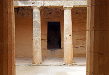 An Underground Chamber At The Tombs Of The Kings In Paphos Cyprus With Old Eroded Sandstone Columns Surrounding A Dark Empty Doorway