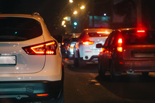 Traffic Jam In Evening Rush Hour, Blurred Night City Lights And Car Headlights, Abstract Concept Of Urban Transportation And Exhaust Pollution