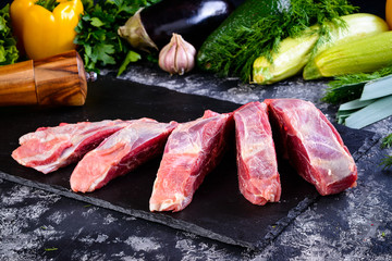 Wall Mural - Raw fresh meat lamb mutton saddle with herbs and spices on stone slate plate