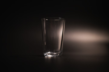 Water is poured into a transparent glass on a dark background