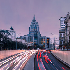 the evening traffic light trails on the modern building background in moscow russia