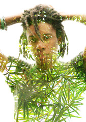 Wall Mural - Double exposure of a dark skinned man with dreadlocks and hands behind head combined with a photograph of lush, green tropical plants