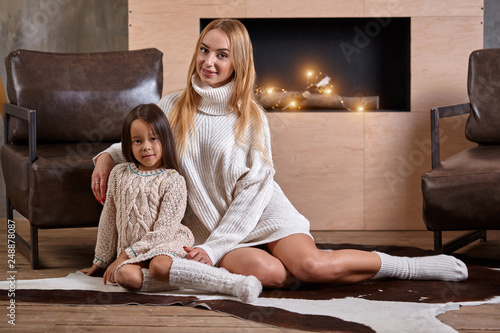 Mom With Little Girl Relaxing On Floor Near A Cozy Sofa Christmas