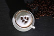 Milchschaum in einer Tasse garniert mit Kaffeebohnen