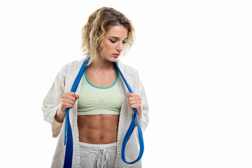 Wall Mural - Female wearing martial arts uniform holding blue belt