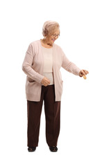 senior woman smiling, holding a biscuit and looking down