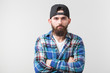 © satura_ - Hipster, lifestyle and people concept - Angry bearded man in a cap posing over the white background