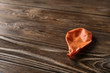 © New Africa - Orange deflated balloon on wooden background, space for text