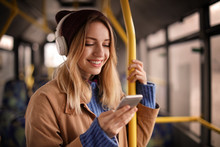 Young Woman With Headphones Listening To Music In Public Transport