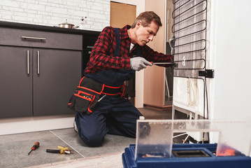 Wall Mural - New refrigerator installation. Senior male technician checking refrigerator