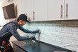 © Friends Stock - Electricity protection. Side view of young handyman with perforator