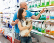 © JackF - Portrait of family couple with dog  choosing dry food in pet store