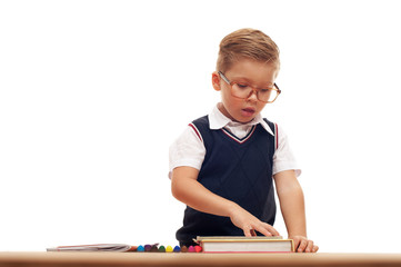 Funny cute little boy posing at school desk