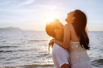 Asian couple are happy with love on the beach at summer weekend holiday.