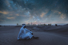 Arabic Man With Kandura Walking In The Desert At Sunset Time
