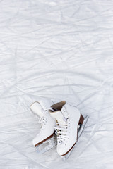 close up of figure skates over ice background with marks from skating or hockey