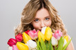 © LIGHTFIELD STUDIOS - young attractive spring woman holding bouquet of colorful tulips isolated on grey