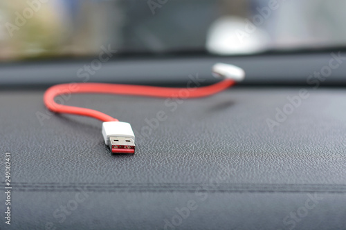 Red Charger Usb Cable With Selective Focus On Blurred Car