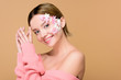 © LIGHTFIELD STUDIOS - cheerful woman with flowers on face isolated on beige
