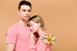 © LIGHTFIELD STUDIOS - handsome boyfriend embracing beautiful girlfriend with flowers on face isolated on beige
