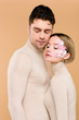 © LIGHTFIELD STUDIOS - handsome man standing with pretty girlfriend with flowers on face isolated on beige