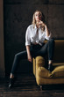 © boykovi1991 - Portrait of a beautiful fashionable woman, blonde, jeans, on a yellow sofa