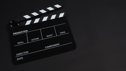 Black Clapperboard or clap board or movie slate use in video production ,film, cinema industry on black background.