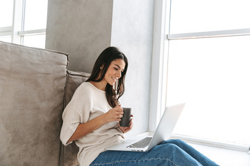 Poster - Smiling young woman using laptop computer