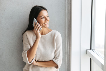 happy young woman standing at the window