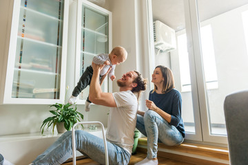 young parents playing with baby
