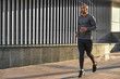 © Friends Stock - Morning workout. Full length portrait of good looking african runner in sportswear doing cardio training in the sunny city