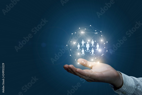 Fotografía A hand holding a digital sphere with human figure models inside.