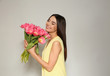 © New Africa - Portrait of beautiful smiling girl with spring tulips on light background, space for text. International Women's Day