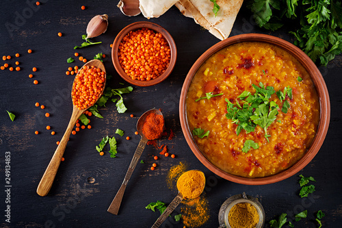 indyjski-dal-jedzenie-tradycyjna-indyjska-soczewica-zupa-indian-dhal-pikantne-curry-w-misce-przyprawy-ziola-rustykalne-czarne-drewniane-tla-widok-z-gory-autentyczne-danie-indyjskie-nad-glowa-lezal-plasko