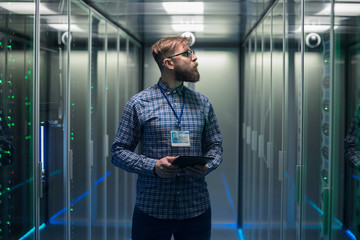 adult bearded engineer in server room