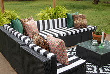 Outdoor Lawn Furniture With Black And White Crisply Striped Upholstery And Assorted Pillows Grouped Around A Table With Ferns On A Patio In Yard With Grass And Trees