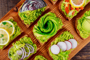 Wall Mural - Freshly made vegetarian sandwich with whole grain bread, and guacamole on wooden cutting board