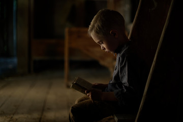 A boy in an old house reading a mysterious book. Fun in search of treasure.