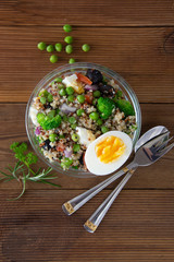Wall Mural - Budha bowl with quinoa, egg, broccoli, green peas, tomatoes. Healthy fresh food, quinoa salad. Rustic wooden background.
