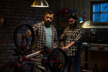 Two men working in a bicycle repair shop