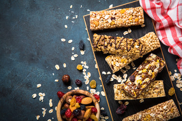 Wall Mural - Granola bar with nuts, fruit and berries on black.