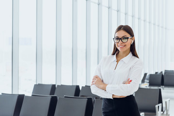 Portrait of smiling attractive business woman in airport hall. Copy space