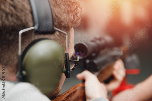 Man directs firearm gun pistol at target firing range or shooting range