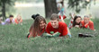 © yurolaitsalbert - pairs of students preparing for the exam, lying on the grass in the Park