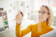 © Seventyfour - High angle portrait of mature businesswoman writing on glass wall in office while planning startup project, copy space